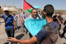 Un hombre enseña una pancarta durante una manifestación ante un puesto de control de Beit Jala, cerca de Jerusalén. EFE