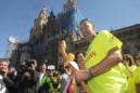 Juan Pedro Orellana (d), que superó un cancer, a su llegada hoy a la Plaza del Obradoio tras recorrer la ruta "1000 km contra el cáncer". EFE