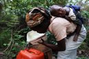 En la imagen, un mujer recoge agua cerca a su pequeña casa, ubicada en Mkhulamini, 400 kilómetros al este de Mbabane (Suazilandia). EFE/Archivo