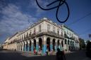 Un cable suelto cuelga mientras algunas personas pasan junto a edificios antiguos en La Habana, Cuba, el sábado 19 de marzo de 2016. El presidente estadounidense Barack Obama visitará la isla el 20 de marzo. Estados Unidos advirtió sobre el riesgo del virus del zika en Cuba, en vísperas del viaje de Obama al país. (Foto AP/Rebecca Blackwell)