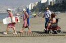 Ascension Luque (d), una discapacitada de 37 años recorre una pasarela de madera en la playa del Zapillo (Almeria), una de las 34 playas con puntos de baño accesibles que se han acondicionado especialmente para personas con movilidad reducida en la provincia de Almeria. EFEUna mujer discapacitada se baña en la playa del Zapillo,(Almeria). EFE