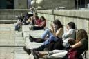 A dos días del comienzo oficial de la Primavera y aprovechando las buenas temperaturas que se vienen registrando desde hace un mes, grupos de jóvenes que visitan el Monasterio de El Escoria, descansan y toman el sol en la explanada de entrada al monumento.EFE/Archivo