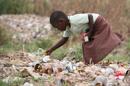 Una niña zimbabwense busca restos de comida en la basura. EFE/Archivo