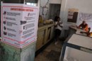 Varias personas conversan en una cafetería, donde se puede ver un cartel alusivo al control sanitario en la capital cubana. EFE/Archivo