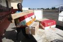 Un hombre liberiano descarga un equipo de protección y otros materiales para combatir el virus del ébola en el aeropuerto de Spriggs Payne en Monrovia, Liberia, hoy, miércoles 2 de abril de 2014. EFE